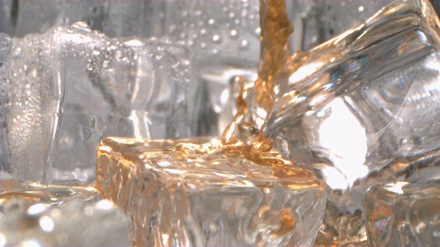 酒精饮料在高速倒入冰在玻璃杯中视频下载