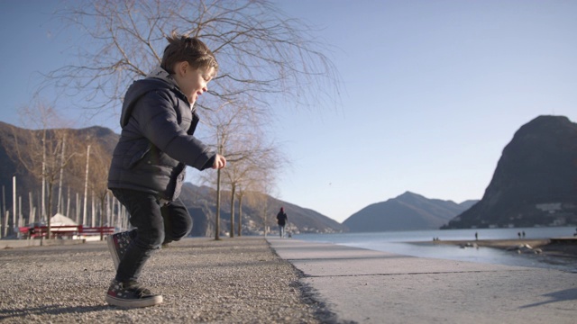 日落时分，幼童在湖边跳入父亲的怀抱视频素材