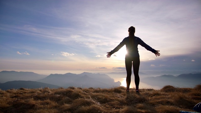 女徒步旅行者在自由姿势看风景，湖和山下的山视频素材