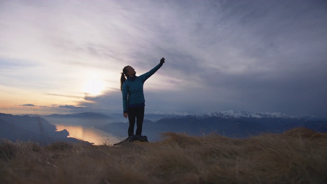 女性站在山顶拍摄日落视频素材