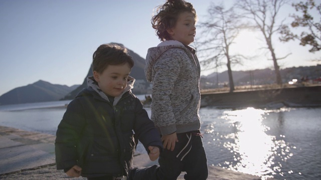 两个小男孩在夕阳下慢镜头奔跑视频素材