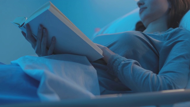女病人躺在病床上看书视频素材