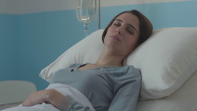 年轻病人躺在床上接受静脉注射治疗视频素材