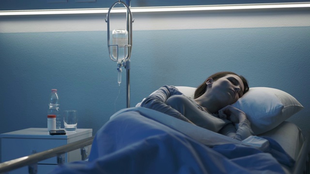 一个女人躺在病床上接受静脉注射治疗视频素材
