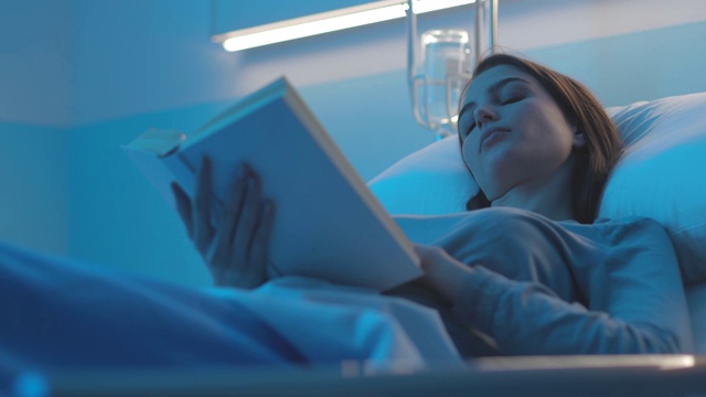 女病人躺在病床上看书视频素材