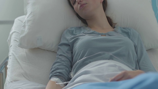 年轻病人躺在床上接受静脉注射治疗视频素材