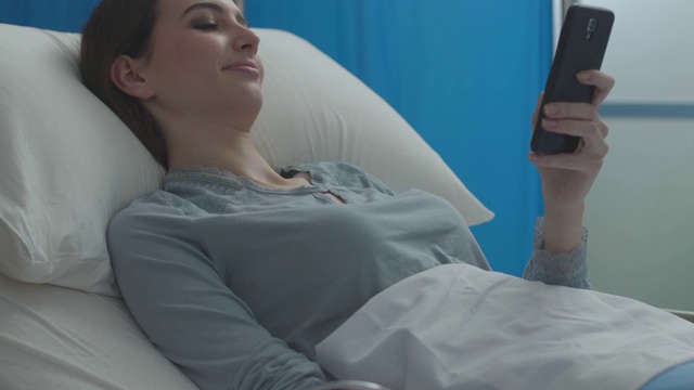 年轻的病人在医院接受静脉注射，和她的手机聊天视频素材