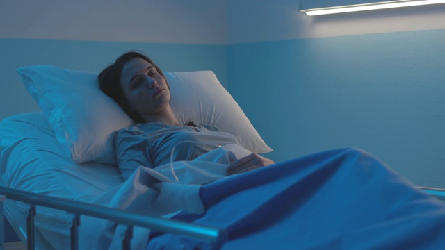 一个女人躺在病床上接受静脉注射治疗视频素材