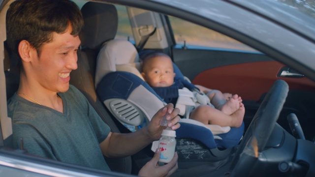 一位亚裔父亲在和儿子检查完一切后关上了车窗，慢动作视频素材