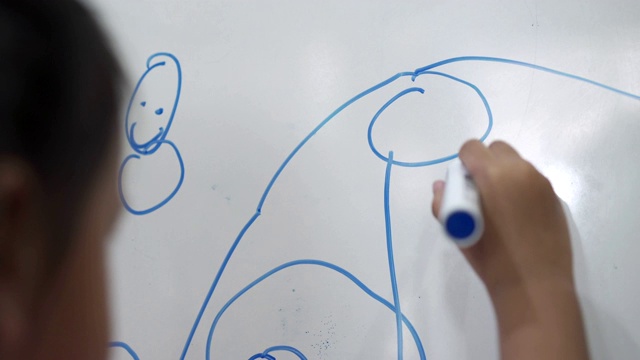 亚洲小女孩用蓝色记号笔在白板上画画和写字视频下载
