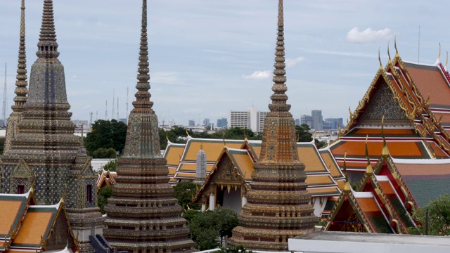 阳光明媚的泰国曼谷，4k卧佛寺。镜头跨越寺庙塔和塔天际线城市景观。视频下载