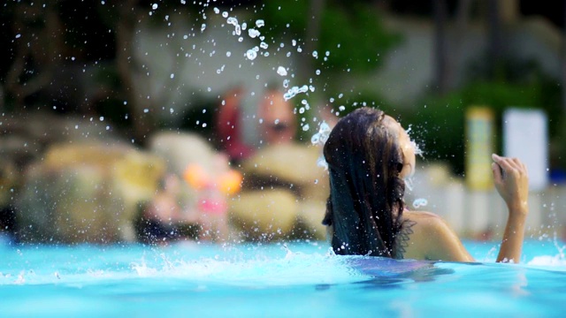 亚洲女人放松在豪华酒店的游泳池享受旅游度假胜地。4 k。视频素材