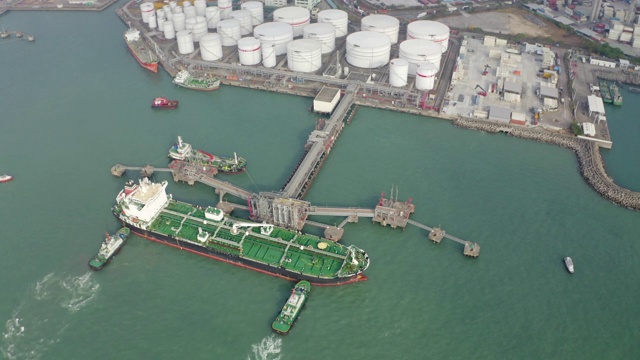 鸟瞰图拖船推油船到装卸码头，从储油罐装卸油视频下载