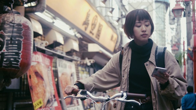 日本女食品快递员在东京寻找送货地址(慢镜头)视频素材