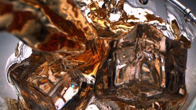 顶视图的威士忌倒与流动在一个玻璃与冰块与相机多莉在视频下载
