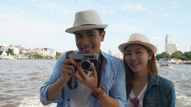 一对亚洲游客在曼谷乘船观光自拍照在湄南河曼谷，泰国。视频素材