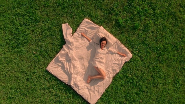 俯视图女人醒来的无人机飞在床上在田野中央视频素材