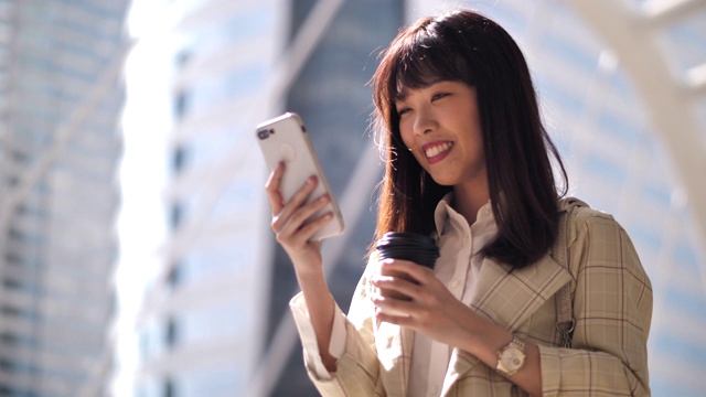 亚洲女性在城市中使用智能手机视频素材