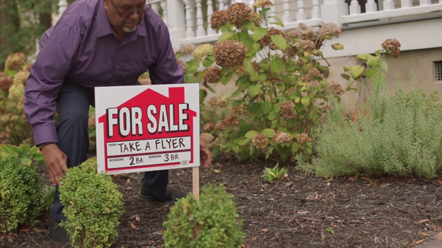 房地产经纪人在前院放了一个“出售”的牌子视频下载