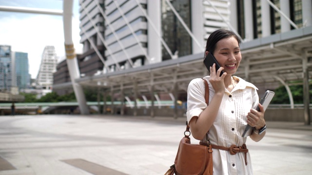 亚洲女商人在城市里打电话视频素材
