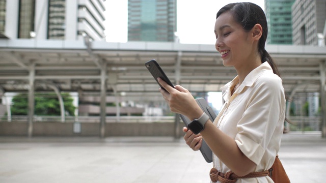 亚洲女商人在城市使用智能手机视频素材