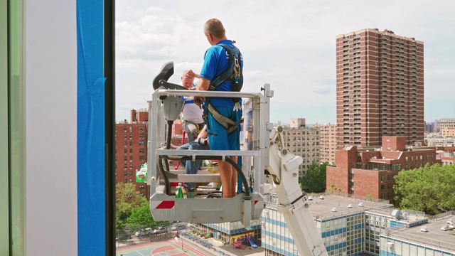 在纽约哈莱姆的街道上工作的升降平台操作员视频下载