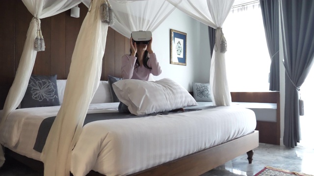 亚洲女性在卧室里使用VR眼镜视频素材