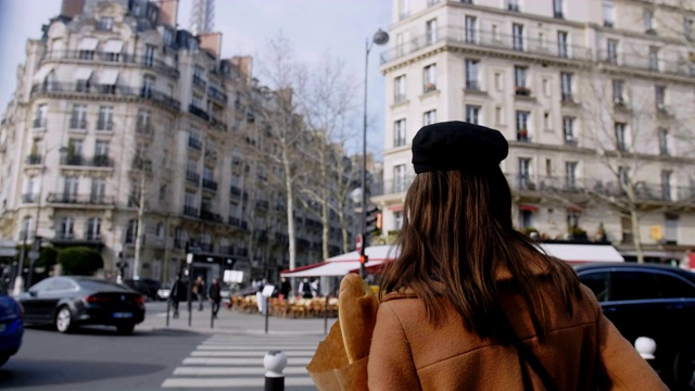 电影移动在美丽快乐的女游客走在繁忙的巴黎街道与纸购物袋慢动作。视频素材