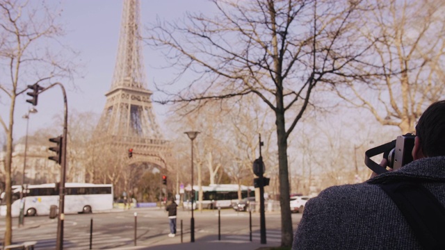 后视图快乐的自由职业男性摄影师拍照的巴黎埃菲尔铁塔与复古电影相机的慢动作。视频素材