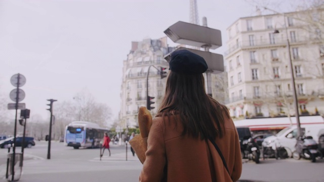 镜头跟随美丽快乐的美食博客女子走在巴黎街头购物纸袋慢镜头。视频素材