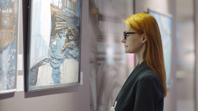 红发女游客在美术馆欣赏绘画视频素材