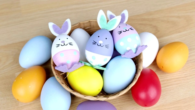 五彩缤纷的复活节彩蛋放在木桌上，复活节快乐理念。视频素材
