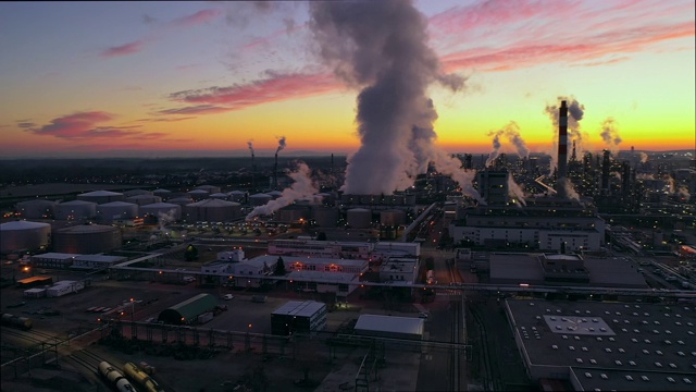 高空俯瞰黄昏时炼油厂上空升起的浓烟视频素材
