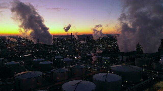 黄昏时分，炼油厂和城市上空升起浓烟视频素材