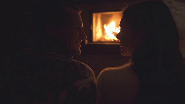 微笑的夫妇坐在壁炉旁视频素材