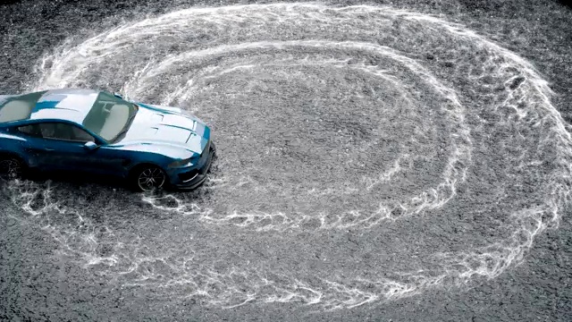 在潮湿的沥青上漂流跑车。旋转车轮溅起的水花和泡沫。视频素材