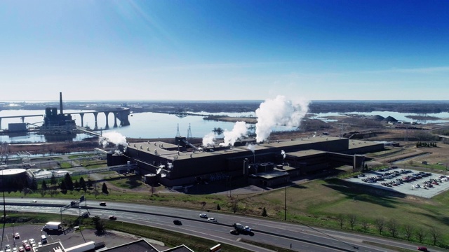 工业是否意味着污染?该工厂位于明尼苏达州五大湖之一的苏必利尔湖岸边。加速无人机视频与电影的复杂轨道和全景相机运动。视频下载