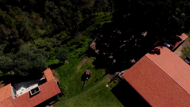 从空中俯瞰美丽的墨西哥村庄里的鲜花、干草车、房屋和山脉。视频下载