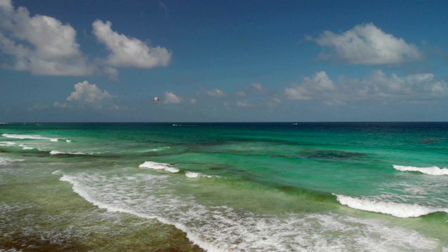 鸟瞰图美丽的海滩与海藻和加勒比海与游客滑翔伞。视频下载