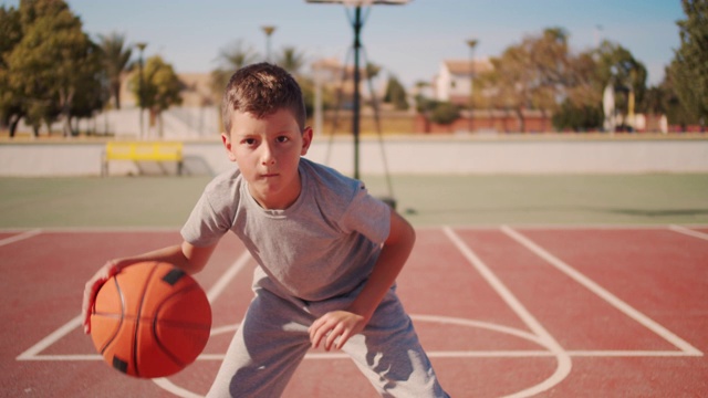 可爱的孩子在打篮球。一个男孩在练习投篮视频下载
