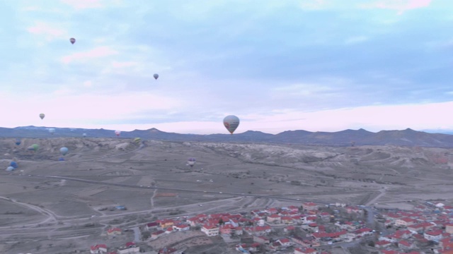 热气球飞过土耳其卡帕多西亚红山谷的鸟瞰图视频素材