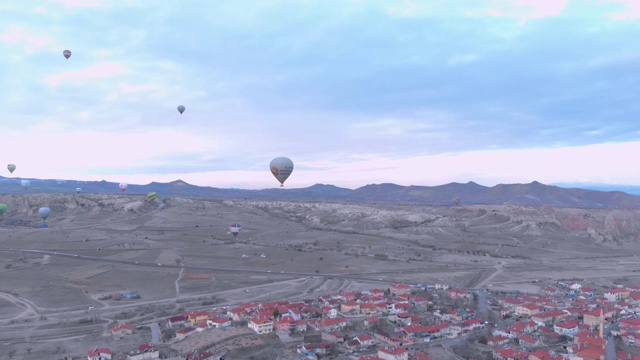热气球飞过土耳其卡帕多西亚红山谷的鸟瞰图视频素材