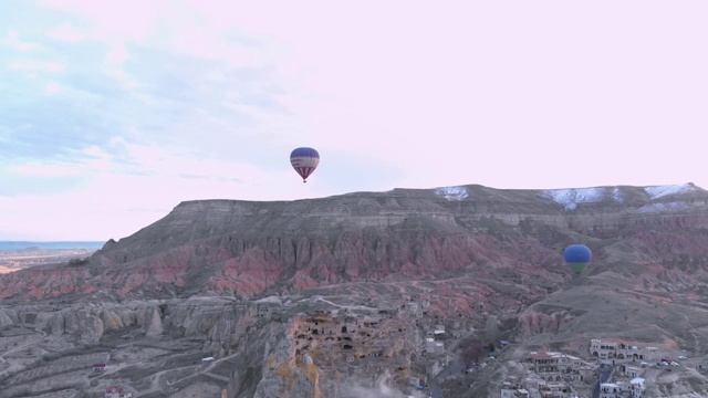 热气球在土耳其卡帕多西亚红山谷上空飞行的鸟瞰图视频素材