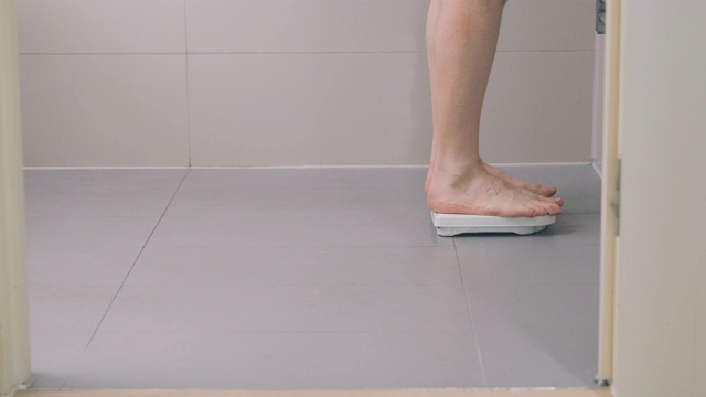 一名男子在豪华浴室里用秤称体重视频素材