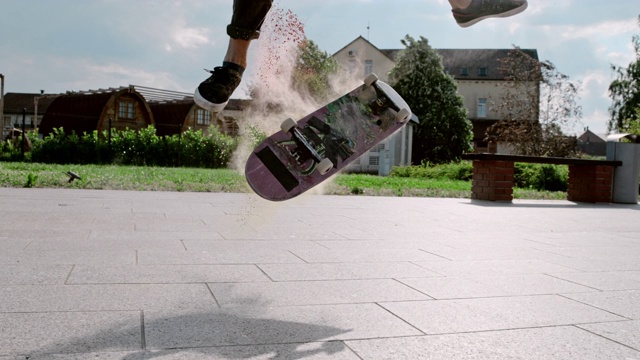 超级慢动作年轻人翻转滑板与粉末在阳光广场视频素材