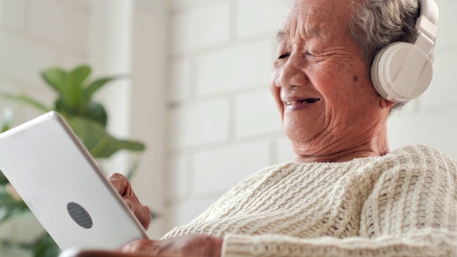 亚洲老年妇女在家中使用平板电脑搜索冠状病毒或Covid-19病毒信息以预防疫情。高级技术、老年人、退休、生活方式、医疗保健和医疗、东南亚和东亚:50岁以上人群、冠状病毒或Covid-19视频下载