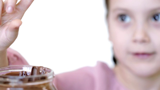 孩子用手指蘸巧克力奶油，吃手指上的巧克力视频素材