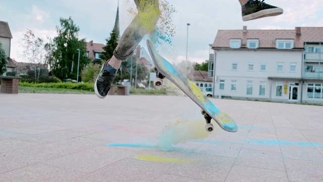一个年轻人在城市广场上用粉末翻转滑板视频下载
