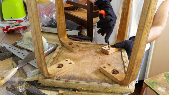 女工匠用螺丝刀修复旧椅子视频下载
