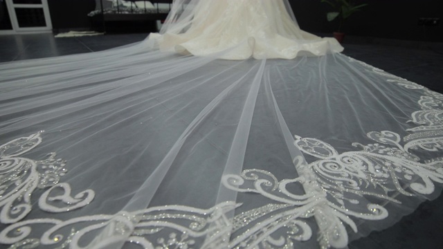 一件白色婚纱延伸到地板上的长长的薄纱的特写视频素材